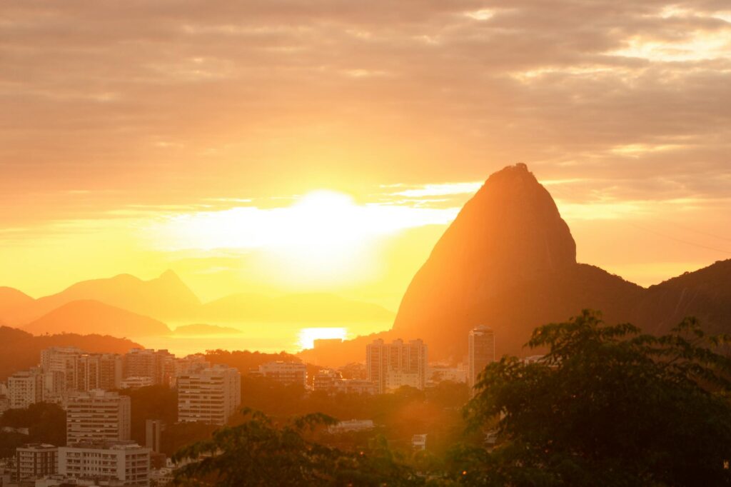 Stunning sunrise view of Rio de Janeiro cityscape with Sugarloaf Mountain in the background.